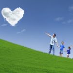 Family stroll in park under heart clouds